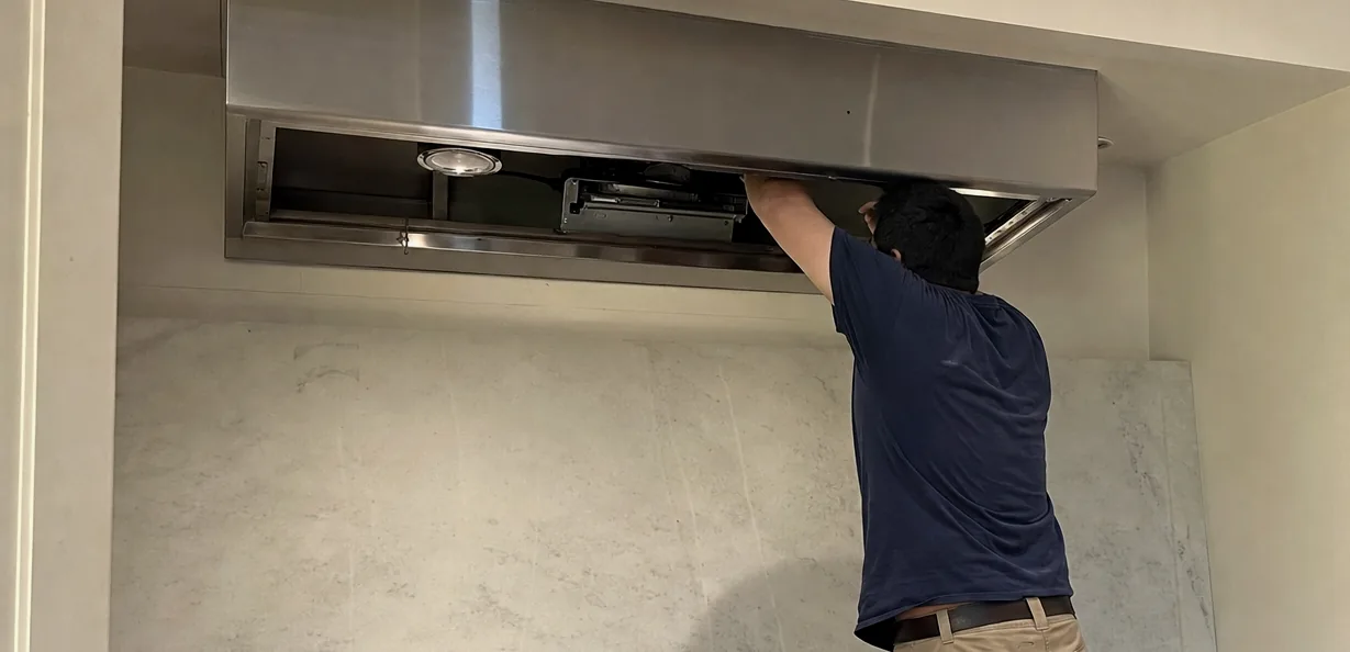 The right of a hood service - the open canopy, the light lens and the baffle filters leaning on the counter